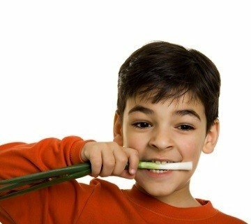 Boy eating spring onions - scallions